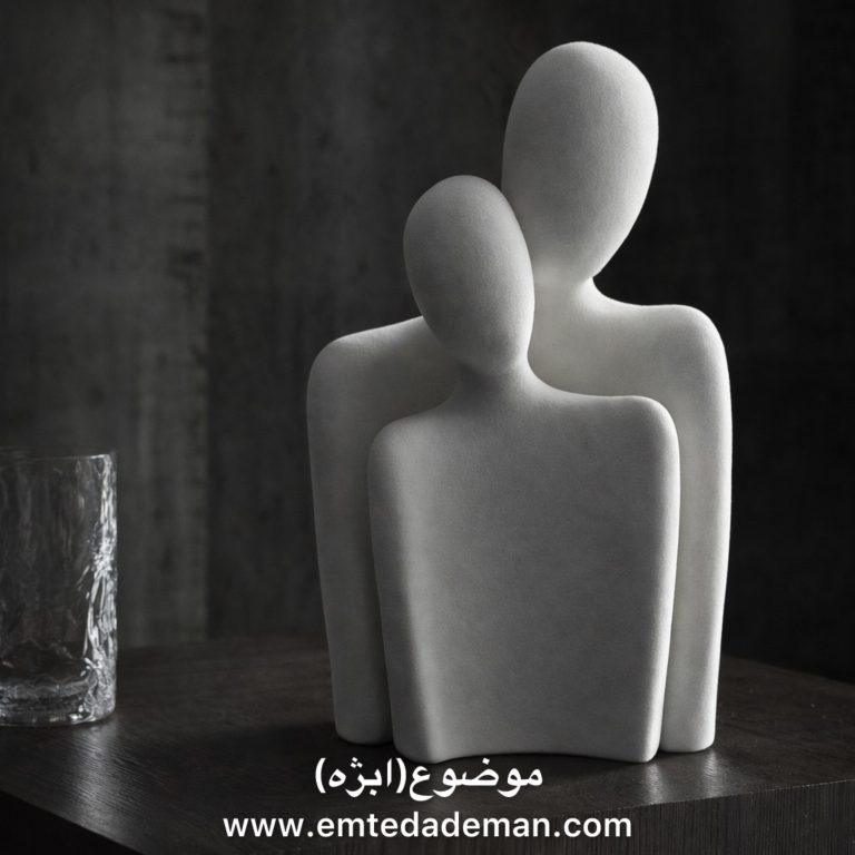 تندیسی مدرن و سفید رنگ که دو فیگور انسانی بدون چهره را نشان میدهد که یکی در دل دیگری جای گرفته است؛ نمادی از ادغام و رابطه درونی.