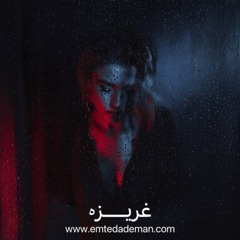 چهره‌ی انسانی در پشت شیشه‌ای خیس از قطرات باران، نیمه‌پنهان در تاریکی با نور قرمز و آبی؛ تصویری نمادین از بروز غریزه در مرز آگاهی و ناهشیار.